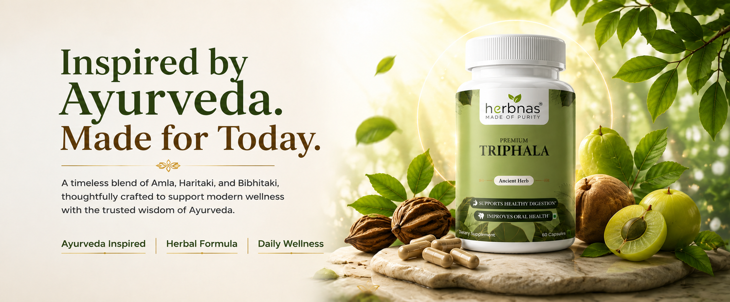 A bottle of HerbNas Triphala herbal supplement displayed on a rustic wooden surface with green leaves, walnuts, and a sliced green kiwi. The left side features promotional text reading 'Inspired by Ayurveda.