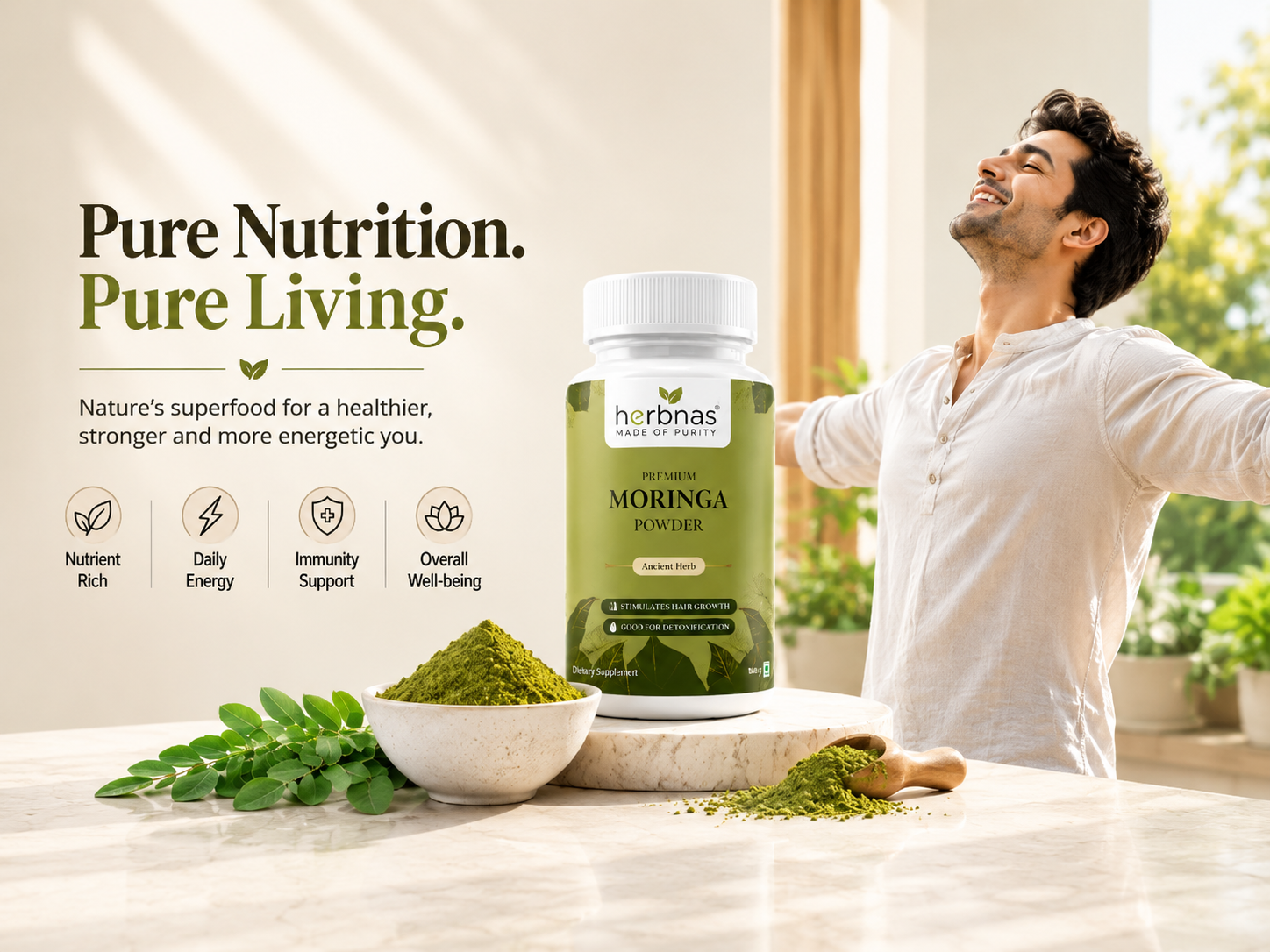 A man in a white shirt stands in a bright kitchen-like setting with arms outstretched, beside a bottle of herbnas Pure Moringa Powder. A bowl of green powder and loose green herbs sit on a marble countertop, with marketing text on the left: 'Pure Nutrition.